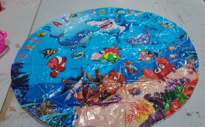 Round plastic mat with underwater animal design on a white surface