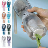 Portable water bottle with multiple color options held by a hand against a light blue background.