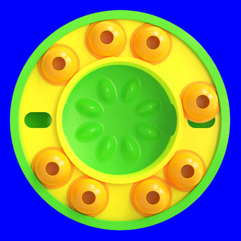 Round yellow and green toy with orange circular elements on a white background
