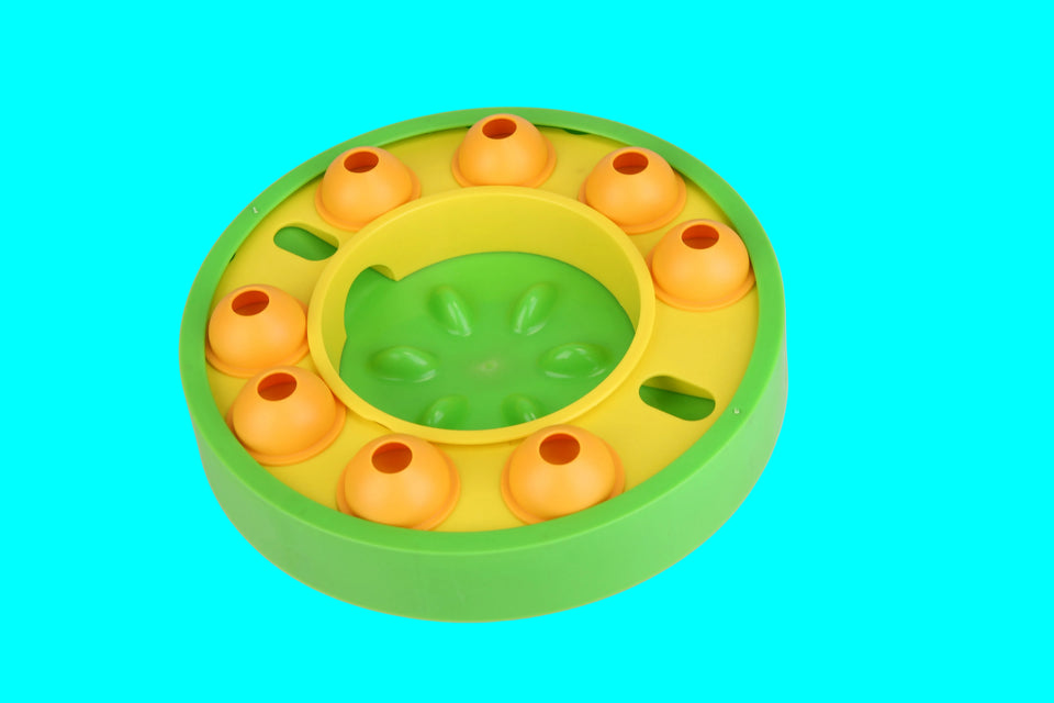 Green and yellow puzzle toy with orange components on a light gray background