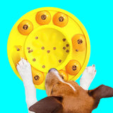 Dog interacting with a yellow puzzle toy filled with treats on a white background