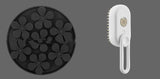 Black silicone mold with flower shapes and a white handheld cleaning brush on a white background
